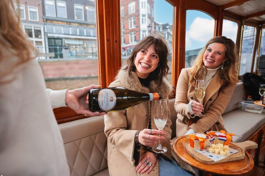 Amsterdam: Canal Cruise with Bubbles & Bites - Boarding and settling in on the covered boat
